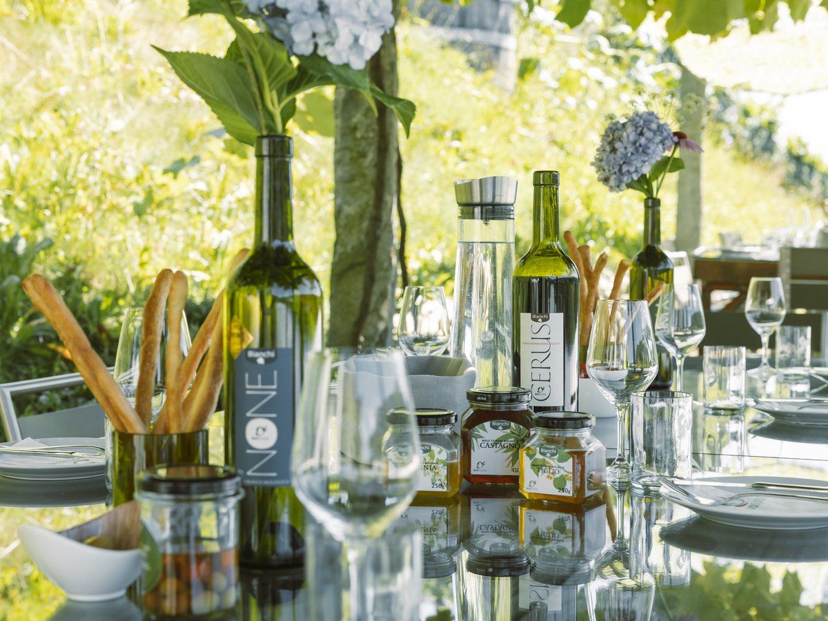 The Bianchi tasting table under the pergola, wine and honey set together